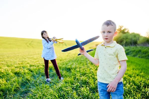 Running Boy Girl Holding Two Yellow Blue Airplanes Toy Field — Stock Photo, Image