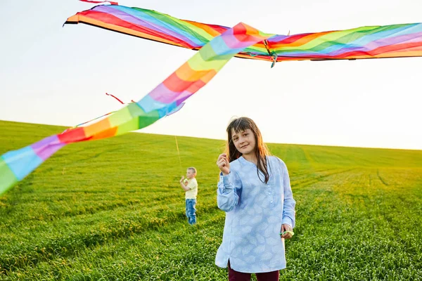 stock image Happy children launch a kite in the field. Little boy and girl on summer vacation.