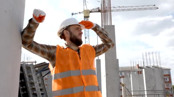 Rakentajan Korjaaja Turvakypärän Liivin Esimies Seisomassa Työpaikallaan Rakenteilla Olevassa Rakennuksessa — kuvapankkivideo