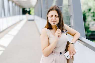 Sokakta yürürken cep telefonu tutan mutlu genç iş kadını. Toplantıya yürüyen güzel bir kadın.