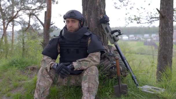 Ein Mann Militäruniform Und Schusssicherer Weste Sitzt Wald Der Nähe — Stockvideo