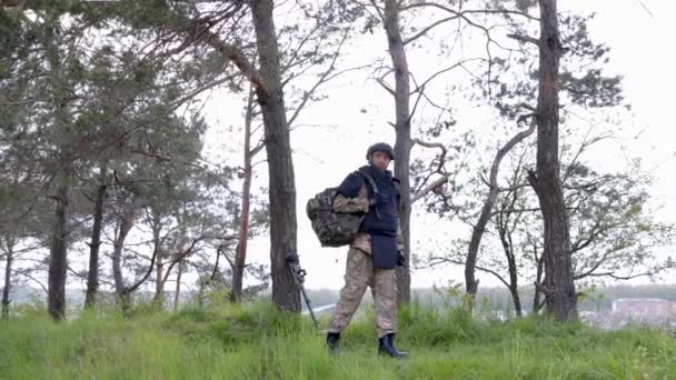 身穿制服和战术背心的年轻士兵在森林里工作 准备在一个临时的森林基地采取行动 一名男子在该地区从事排雷工作 — 图库视频影像