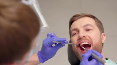 Diş hekimlerine muayene olan bir adam. Diş sağlığı önleme çalışmalarına genel bakış