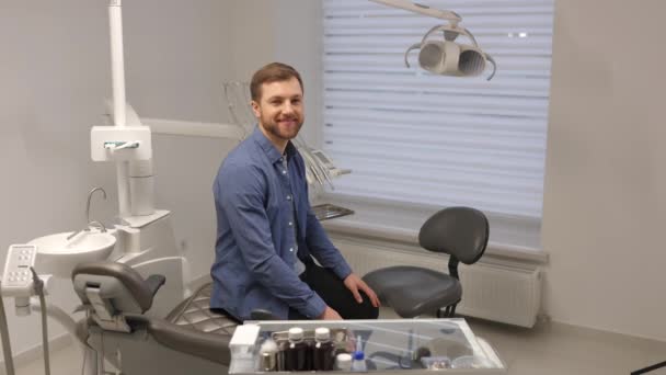 Симпатичний Молодий Чоловік Сидить Кріслі Красивому Сучасному Стоматологічному Кабінеті Посміхаючись — стокове відео