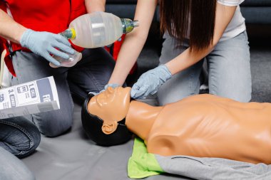 Ambu poşeti tutan kadın. Kalp masajı kardiyopulmoner resüsitasyon eğitimi alıyor. Sağlık görevlileri ilk yardım uygulamasının hayat kurtardığını gösteriyor..