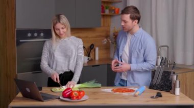 Birlikte yemek pişirmek. Genç ve güzel kadın ve erkek mutfakta yemek tadıyorlar..