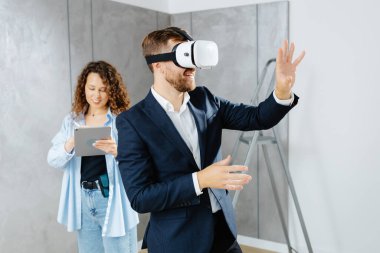 Sanal gerçeklik gözlüğü takan bir adam, gelecekte tasarımcıyla inşaat alanında olacağını hayal ediyor. Modern bir tasarımda tamir kavramı