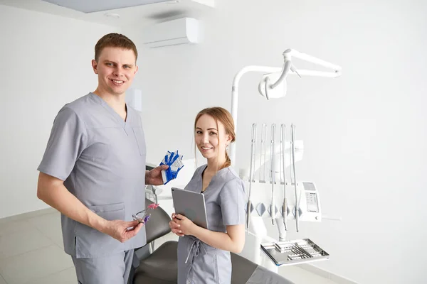 Οδοντίατρος Και Βοηθός Στην Εξέταση Δωμάτιο Χαμογελώντας — Φωτογραφία Αρχείου