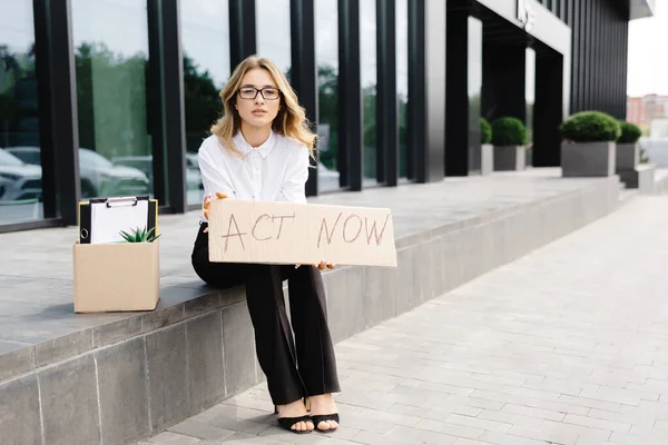 物の箱の隣にポスター法で屋外に座っている女性 失業に対するストライキで美しい女性抗議者 — ストック写真