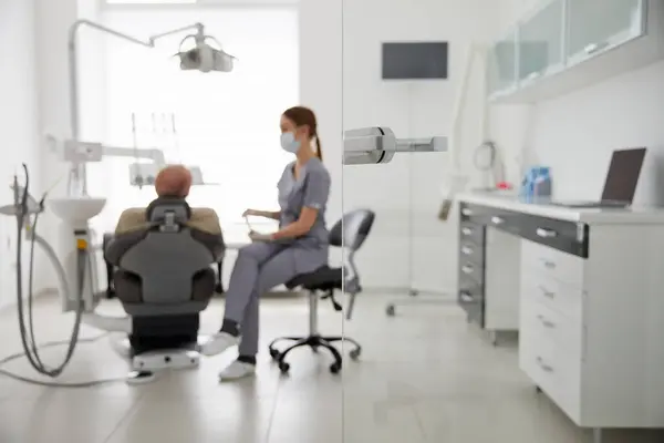 Porträtt Ung Kvinnlig Tandläkare Står Vid Mitten Vuxen Man Kliniken — Stockfoto