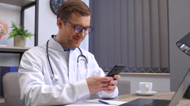 Mężczyzna Lekarz Pracownik Medyczny Nowoczesnej Klinice Okularach Mundurze Biały Płaszcz — Wideo stockowe