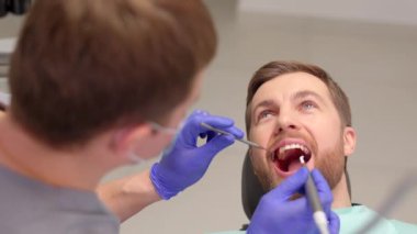 Diş hekimlerine muayene olan bir adam. Diş sağlığı önleme çalışmalarına genel bakış.