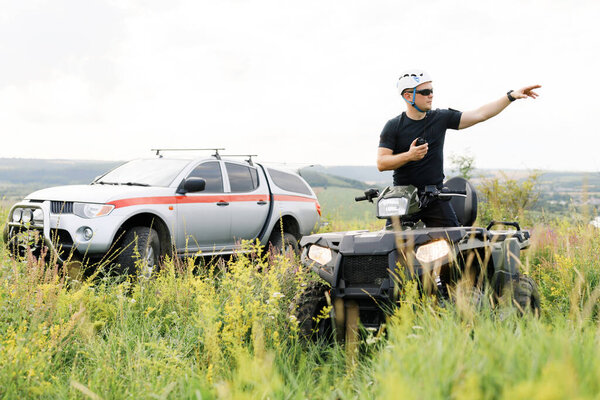 The rescuer, a beautiful athletic physique, rides an ATV in the middle of the field.