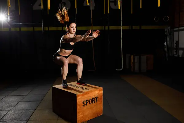 Athletic woman in sportswear jumping on crossfit box in fitness gym. Healthy Lifestyle