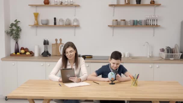 Молодая Женщина Помогает Мальчику Уроками Используя Планшет Глобус Студент Обучающийся — стоковое видео