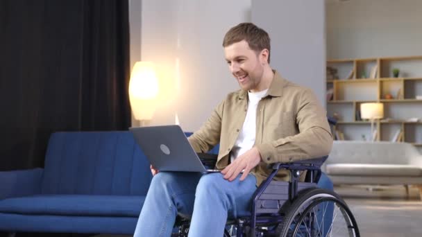 Knappe Man Met Een Handicap Een Rolstoel Met Laptop Knieën — Stockvideo
