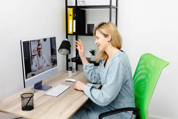 Caucasian doctor video conference call online live talk follow up remotely in medical result with woman sitting at chair at home. Online health care digital service concept