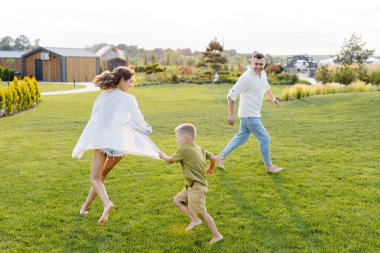 Oğullarıyla birlikte komik vakit geçiren kadın ve erkek..