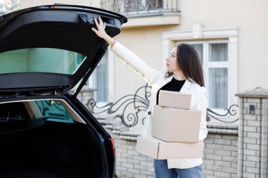 Genç bir iş kadını bir araba bagajından paketler alıyor, arabayla eve geliyor. Kız bagajı kapatmak için düğmeye basıyor..