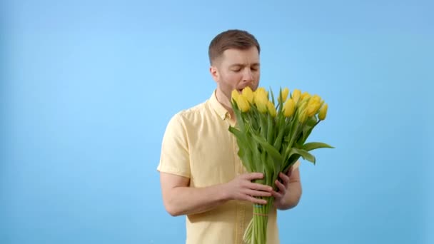 男人捧着一束黄色的花 闻起来打喷嚏 — 图库视频影像