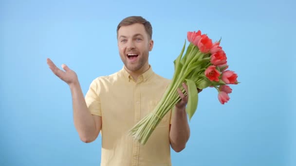 Een Man Staat Met Een Levendig Boeket Rode Tulpen Zijn — Stockvideo