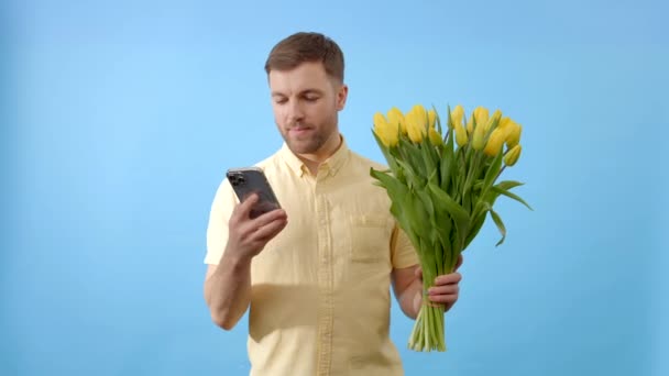 Homem Está Segurando Buquê Flores Coloridas Uma Mão Telefone Celular — Vídeo de Stock