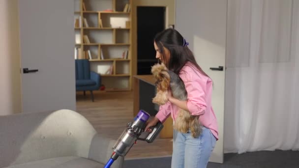 女とともに掃除機と犬で彼女の手真空でザリビングルーム — ストック動画
