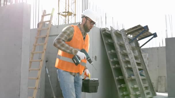 有趣的建筑工人跳舞 戴着头盔的建筑商们跳着积极的舞 身穿建筑工人制服的建筑工程师在他的工作场所跳舞 — 图库视频影像