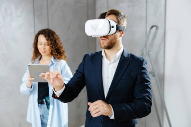 Sanal gerçeklik gözlüğü takan bir adam, gelecekte tasarımcıyla inşaat alanında olacağını hayal ediyor. Modern bir tasarımda tamir kavramı