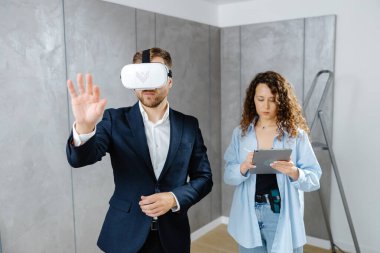 Sanal gerçeklik gözlüğü takan bir adam, gelecekte tasarımcıyla inşaat alanında olacağını hayal ediyor. Modern bir tasarımda tamir kavramı