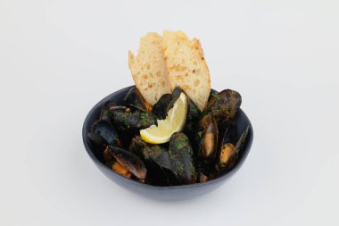 Lezzetli kabuklu midyeler. Beyaz arka plandaki koyu kâsede soslu geleneksel midyeler..