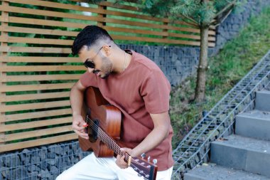 Hintli hippi yaz aylarında piknikte gitar çalardı..