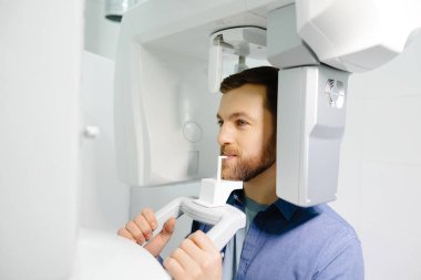 Panoramic image of teeth. A patient in a modern dental clinic takes a panoramic picture of the teeth. Prevention of dental diseases. Accurate diagnosis.Side view.