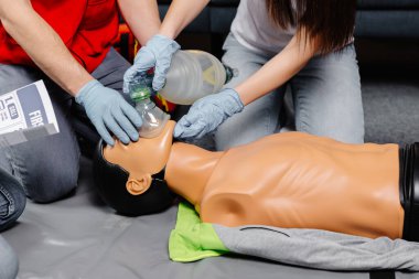 Ambu poşeti tutan kadın. Kalp masajı kardiyopulmoner resüsitasyon eğitimi alıyor. Sağlık görevlileri ilk yardım uygulamasının hayat kurtardığını gösteriyor..