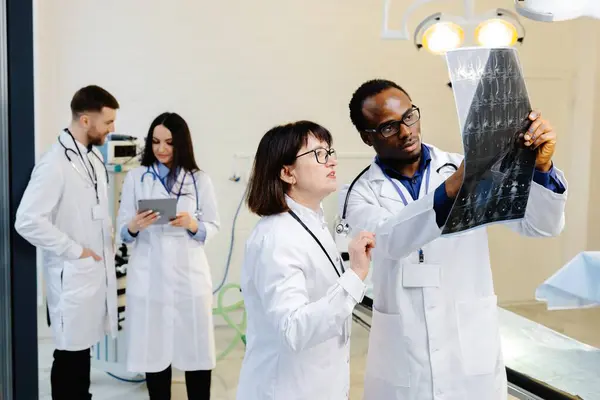 stock image Group of scientists examining data on paper.