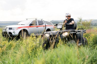 Kurtarıcı, güzel bir atletik fiziğe sahip, tarlanın ortasında bir ATV sürüyor..