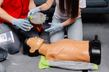 Ambu poşeti tutan kadın. Kalp masajı kardiyopulmoner resüsitasyon eğitimi alıyor. Sağlık görevlileri ilk yardım uygulamasının hayat kurtardığını gösteriyor..