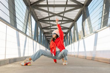 Dışarıda yürüyüp dans eden mutlu güzel bir kadın. Genç kaygısız kız günün tadını çıkarıyor ve dans ediyor..