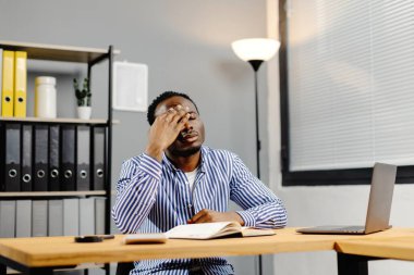 Ofiste bütün gün çalıştıktan sonra baş ağrısı çeken bir iş adamı..