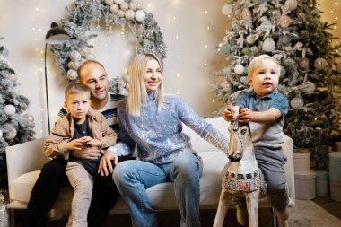 Neşeli aile Noel sabahını birlikte hediyeler açarak ve kahkahalarını paylaşarak kutluyor.