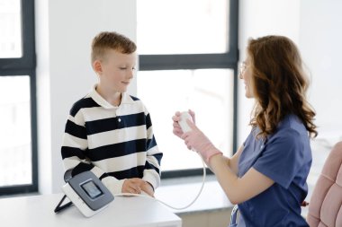Çocuk, doktor muayenehanesinde spirometri yoluyla solunum fonksiyonlarını test ediyor. Akciğer hastalığında solunum fonksiyonu teşhisi.