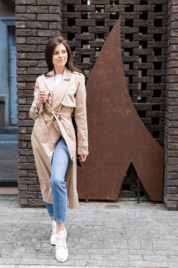 Yağmurluklu güzel sarışın kadın gündüzleri dışarıda tek başına yürüyor..