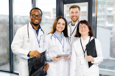 Bir grup doktor hastane ortamında yan yana duruyorlar..