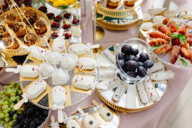 Beyaz çikolatalı kek ve kırmızı süslemelerle süslenmiş dondurmalar ve lüks bir çikolata barında beyaz fiyonklar.