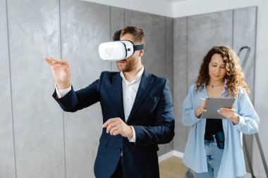 Sanal gerçeklik gözlüğü takan bir adam, gelecekte tasarımcıyla inşaat alanında olacağını hayal ediyor. Modern bir tasarımda tamir kavramı