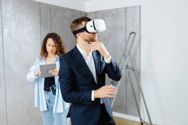 Sanal gerçeklik gözlüğü takan bir adam, gelecekte tasarımcıyla inşaat alanında olacağını hayal ediyor. Modern bir tasarımda tamir kavramı