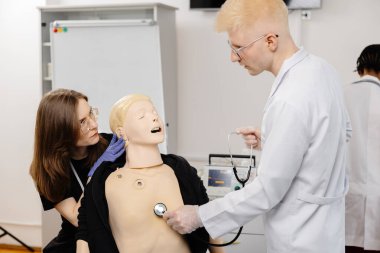 Çalışmalar sırasında steteskop kullanarak anatomik modeli inceleyen çeşitli tıp öğrencileri grubu