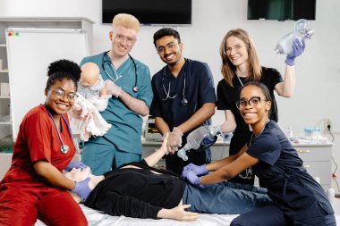 Bir grup sağlık görevlisi, ilk yardım eğitimi sırasında tıbbi bir manikinde kardiyopulmoner resüsitasyon yapmayı öğreniyor.