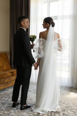 Damat ve gelinin el ele tutuşması, özel günlerinde birlikteliklerini ve bağlılıklarını simgeliyor.