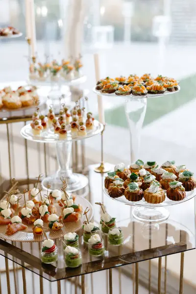 Yemek servisi bir partide leziz aperatifleri sunuyor, onları zarif cam tezgahlara koyuyor.